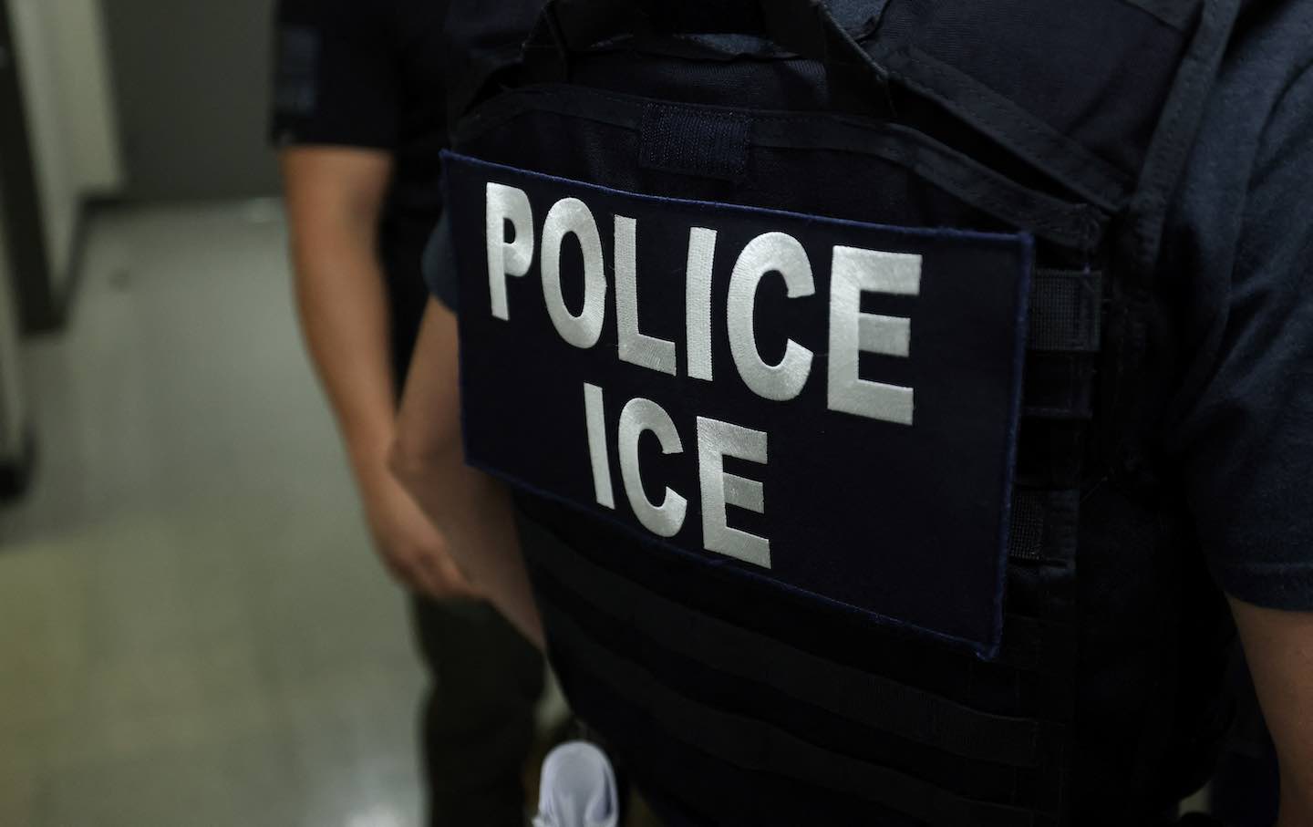 An agent of Immigration and Customs Enforcement waits in a hallway on July 17, 2025.