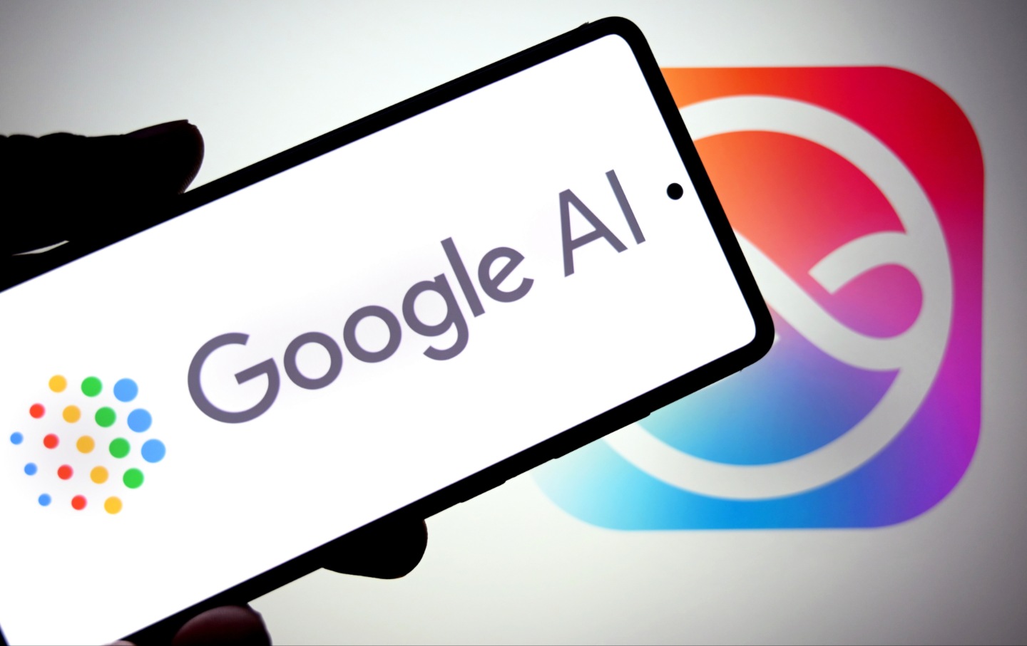 In this photo illustration, a Google AI logo is seen displayed on a smartphone with an Apple Siri logo in the background.