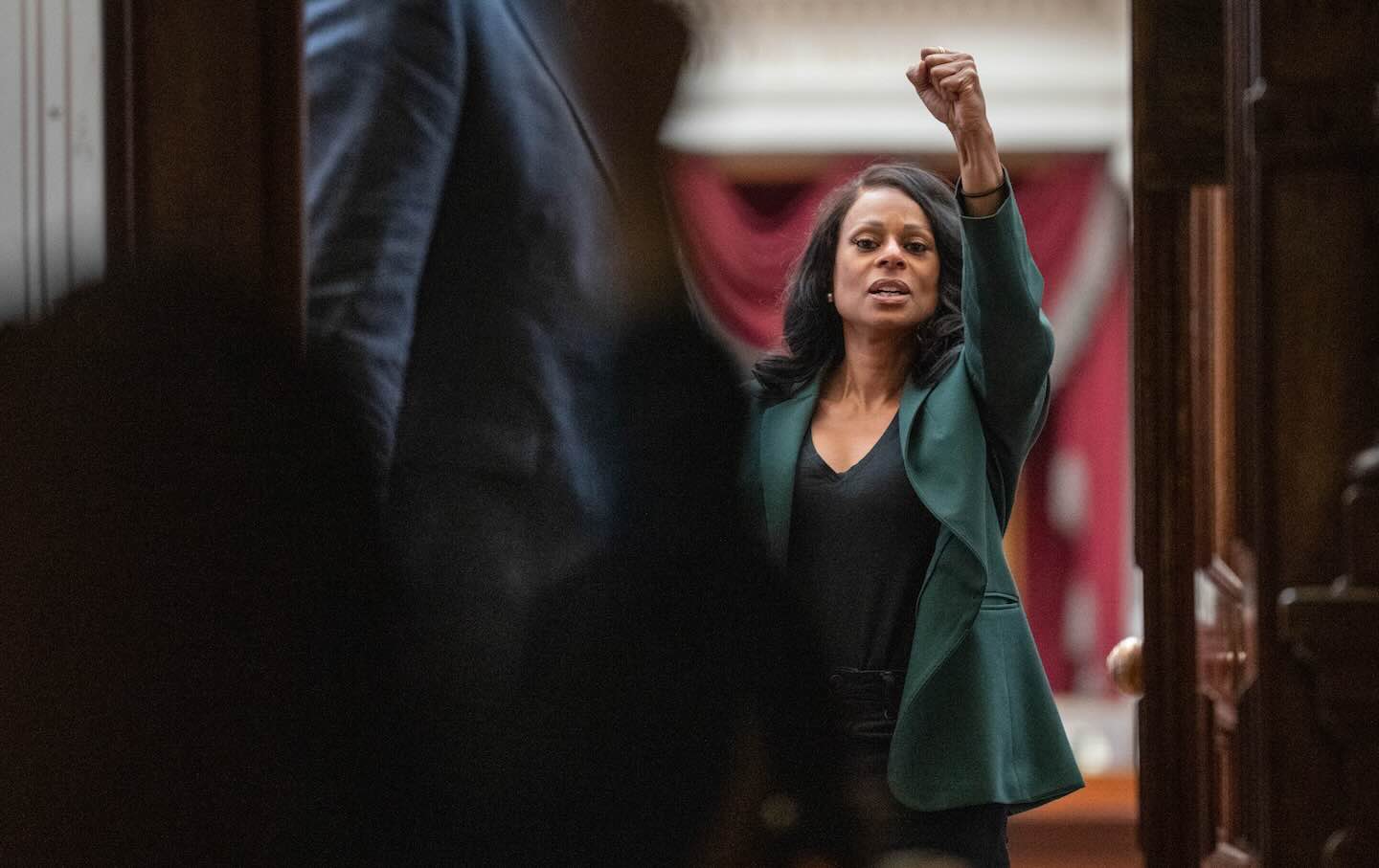 Representative Nicole Collier (D-Fort Worth) raises a fist as she greets supporters from inside the House Chamber at the Texas capitol in Austin, on August 19, 2025.