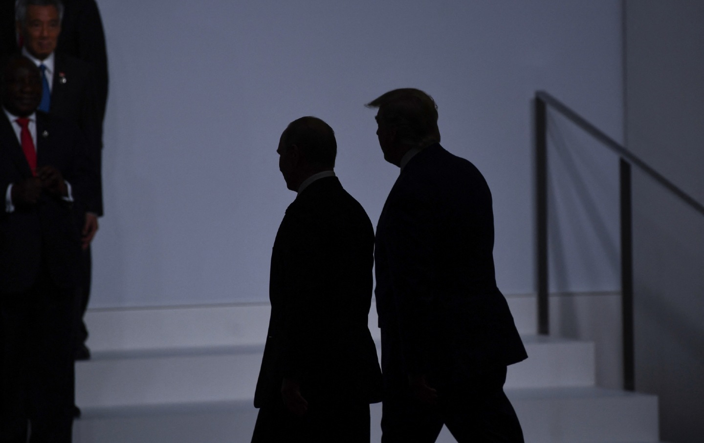 Trump and Putin walk side-by-side silhouetted